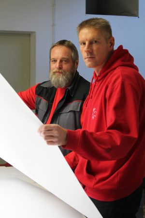 Papiertechnologen Jürgen Siebrecht (links) und Michael Eggers bei der optischen Prüfung eines Künstlerpapiers